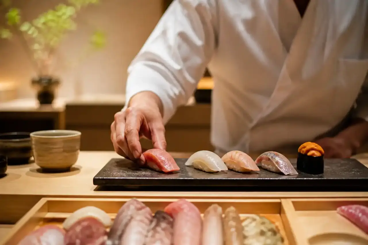 Nigiri unique sur céramique artisanale sombre, éclairage doux et atmosphère wabi-sabi