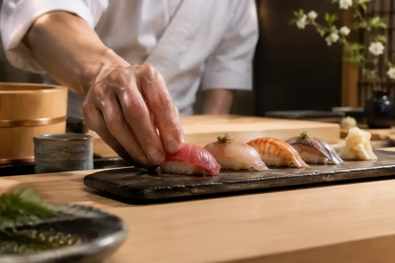 Nigiri de saison présenté sur une céramique artisanale sombre